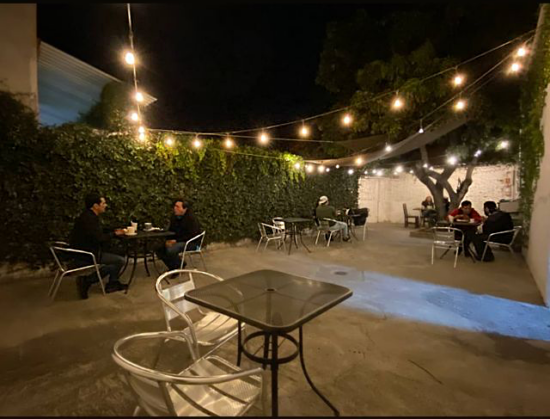The cozy courtyard at Brewers, with cafe tables and outdoor string lights on at night.