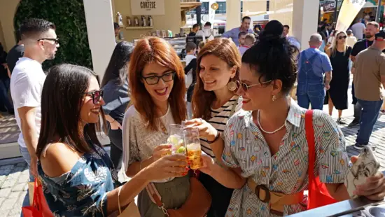 A group of 4 women clink glasses together.