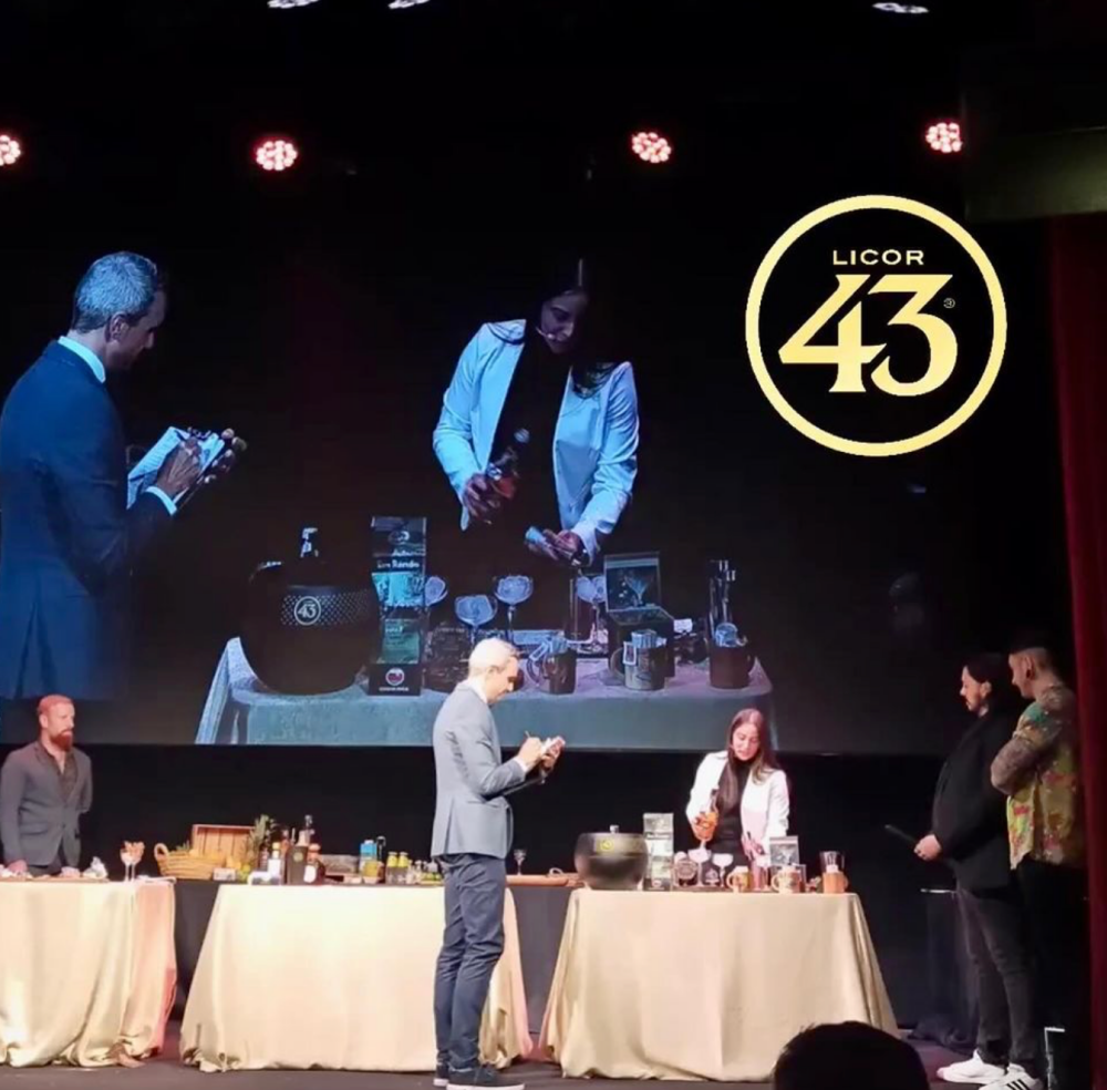 Gabriela Wong competes on a stage behind a table where she's crafting a drink.