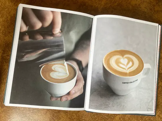 Inside the book, two photos of lattes with latte art. One is still being poured.