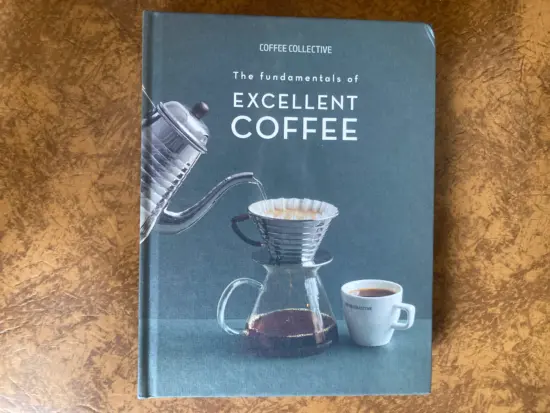 The front cover of the book, blue, with the title in white letters and a photo of a pourover setup.