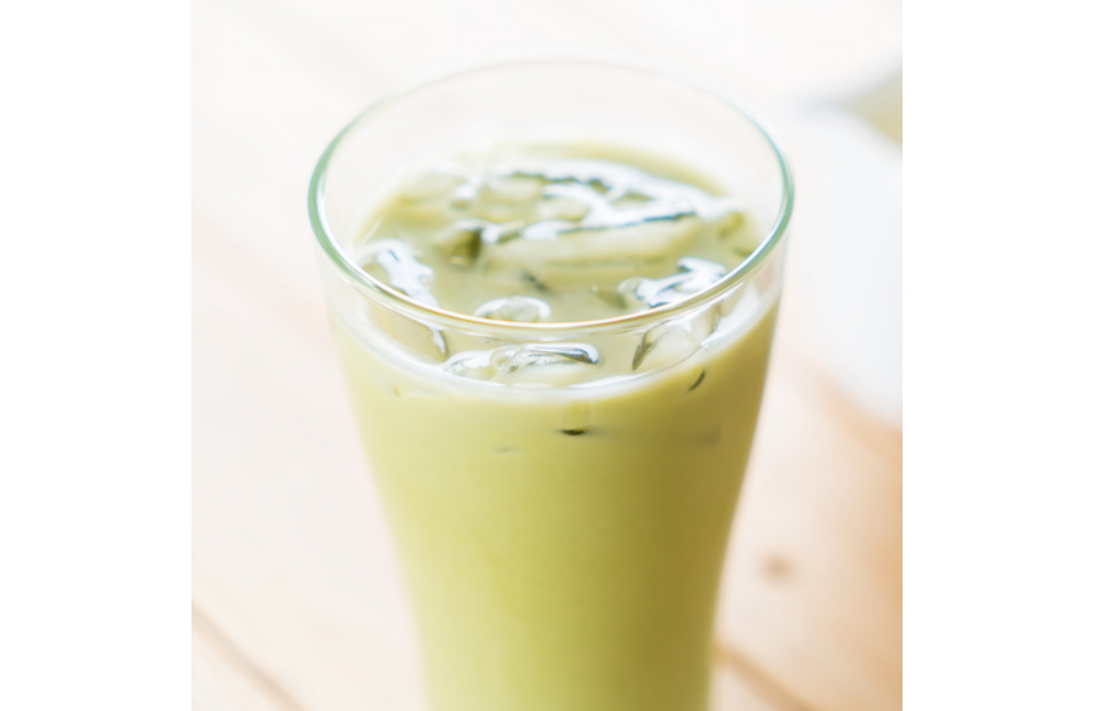 A honey, ginger, coconut matcha latte made with Pacific Foods Barista Series Coconut in a tall glass with ice.