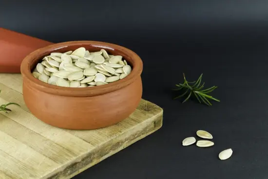 A bowl of dried white pumpkin seeds.