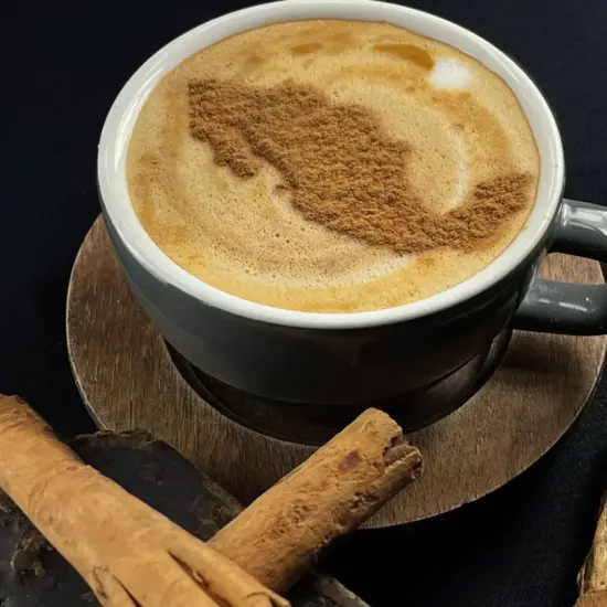 A mug of coffee with an outline of Mexico in cinnamon.