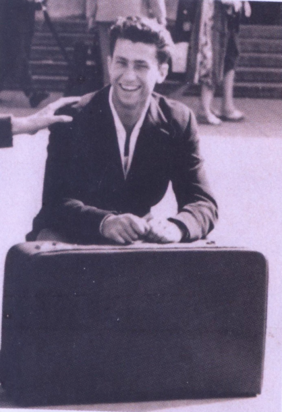 Gianni as a 27-year-old holding a suitcase.