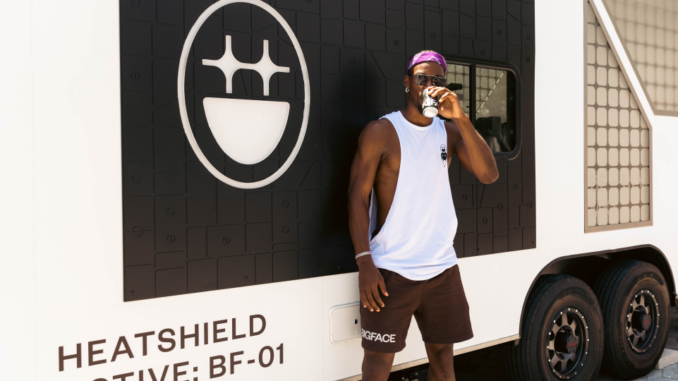 Jimmy Butler drinking coffee outside against a BIGFACE truck.