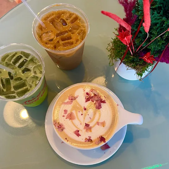 A latte with rose petals on top.