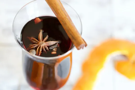A drink with cinnamon stick on top and floating star pod.