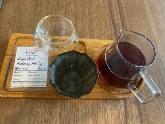 Coffee tray with two drinking vessels and a glass server and coffee info card.