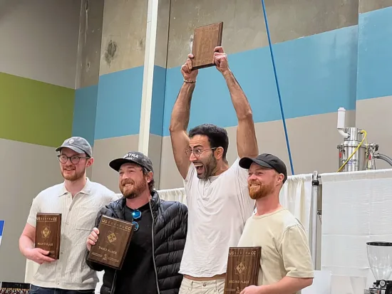 Mehmet with other three of the top fours winners, holding his plaque over his head.