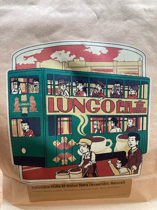 Lungo bag design for Colombian Huila coffee (anaerobic natural). The design is a double decker green bus with coffee cups on the side, with people on the bus doing various things like sleeping, drinking coffee or taking photos.