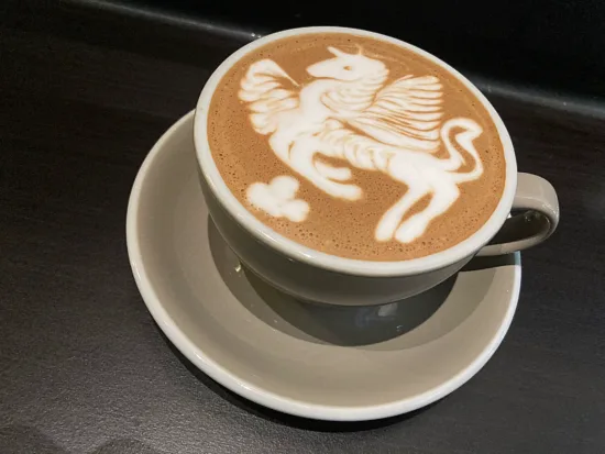 A pegasus/unicorn latte pour in a gray mug.