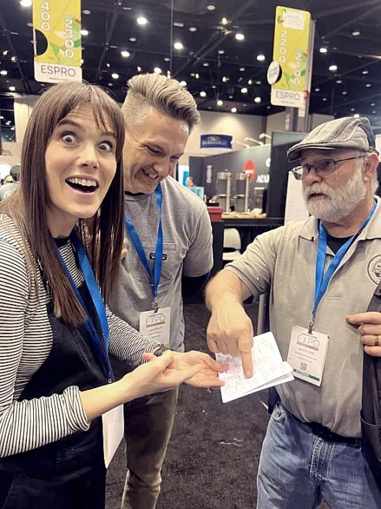 Autumn looks incredulously at the camera while Luke smiles at the pamphlet of Marty's tech notes while Marty points something out in it.