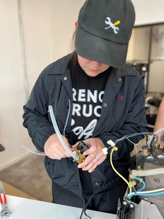 Service Tech Hope Roberts works on machine components from a training course.