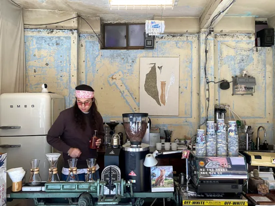 The owner in a pink bandana behind the eclectic bar at Naive.