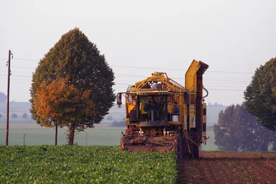 Farmer on reaping farming equipment.