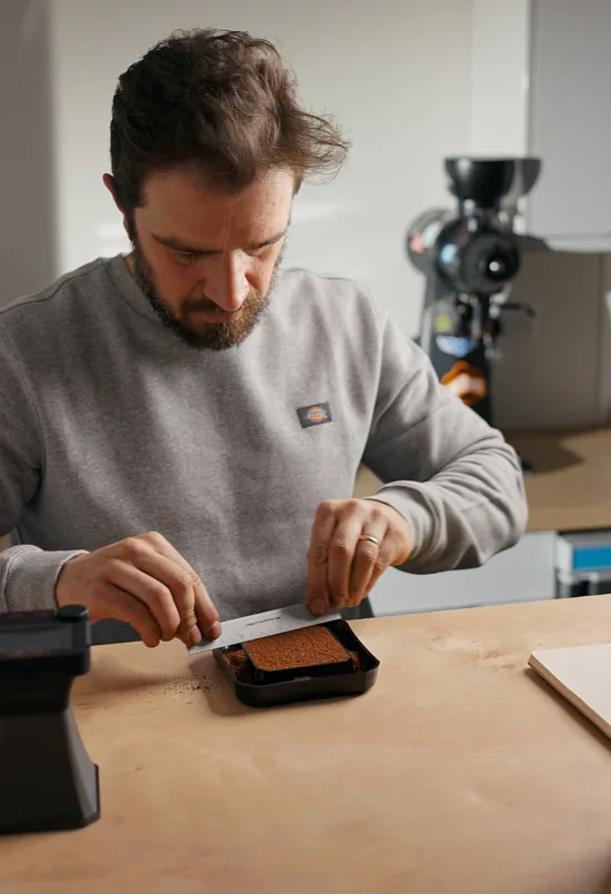 Nikola measuring coffee in a lab.