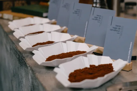 Coffee trays filled with ground coffee, with producer and variety cards for labels.