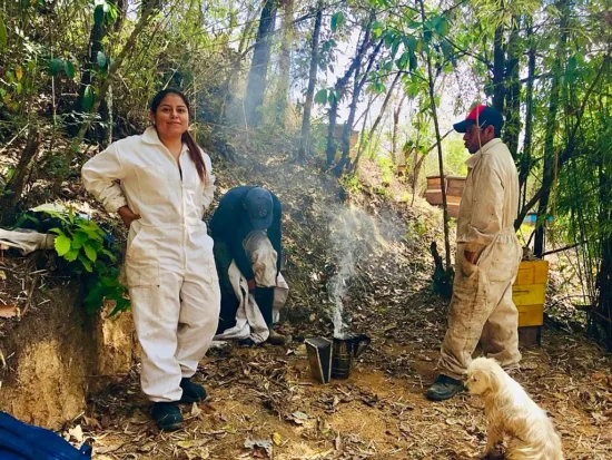 Susi Roblero helps two others with a smoker for beehives.