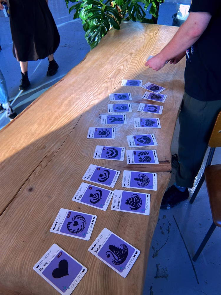 A deck of cards from the “Throw It Down” latte art card game are spread out on a wooden table.